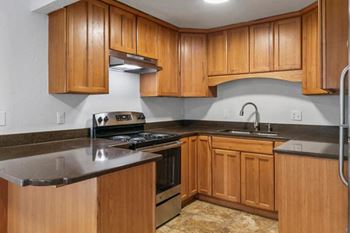 a kitchen with wooden cabinets and stainless steel appliances